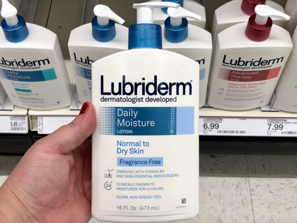 Woman's hand holding lotion in store aisle