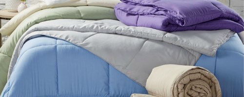Bed made up with multiple comforters in various colors