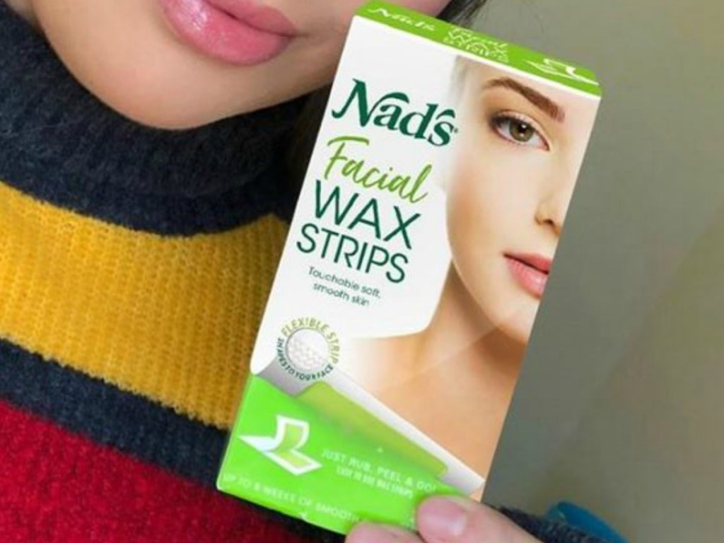 Woman holding a box of facial wax strips