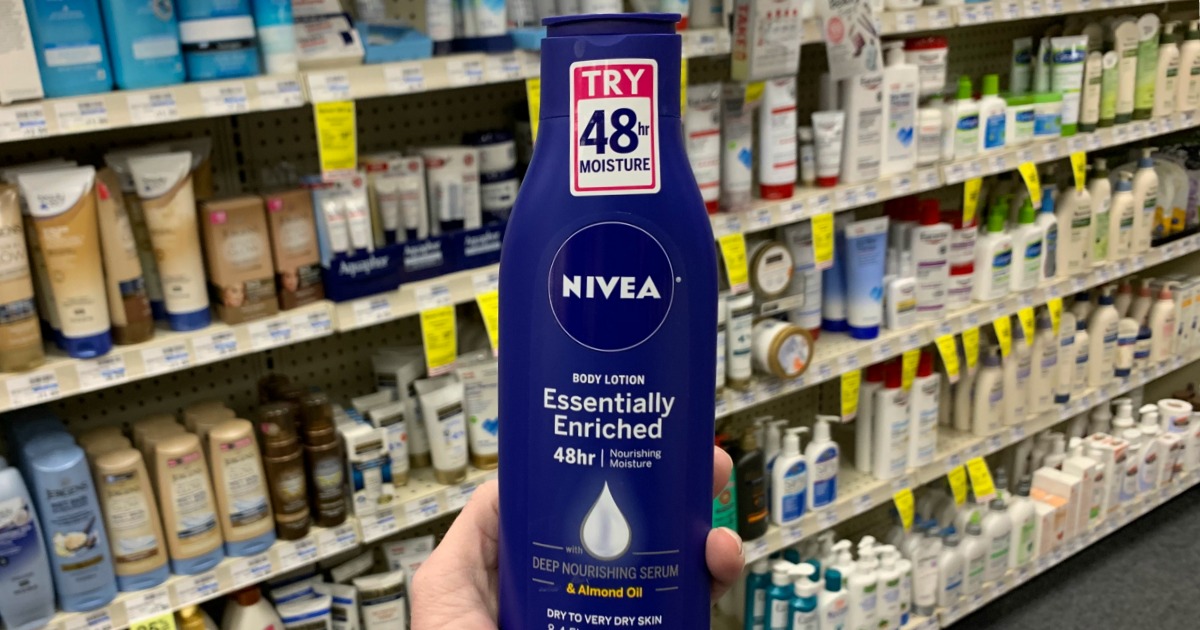 Hand holding Nivea lotion in front of shelf
