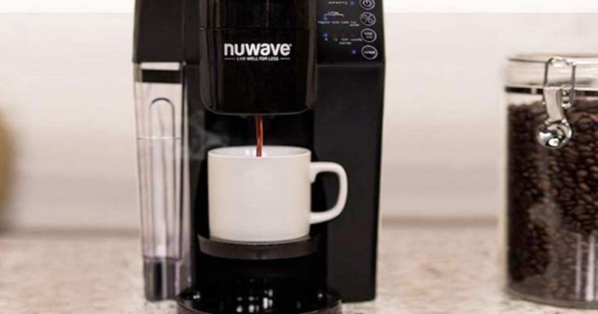 NuWave Coffee Maker, brewing a cup of coffee over a single white mug. There is a glass canister of coffee beans to the right of the coffee maker