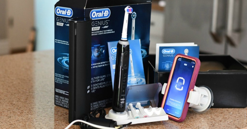 Large rechargeable toothbrush near package with accessories on countertop