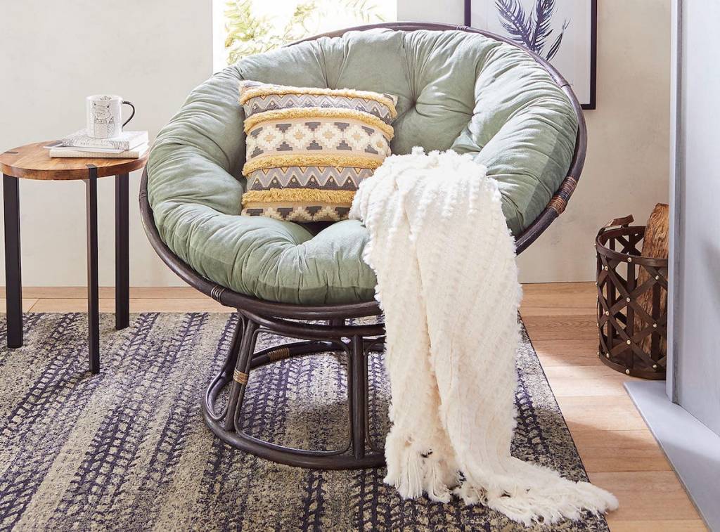 living room with papasan chair with a blanket on it and a pillow