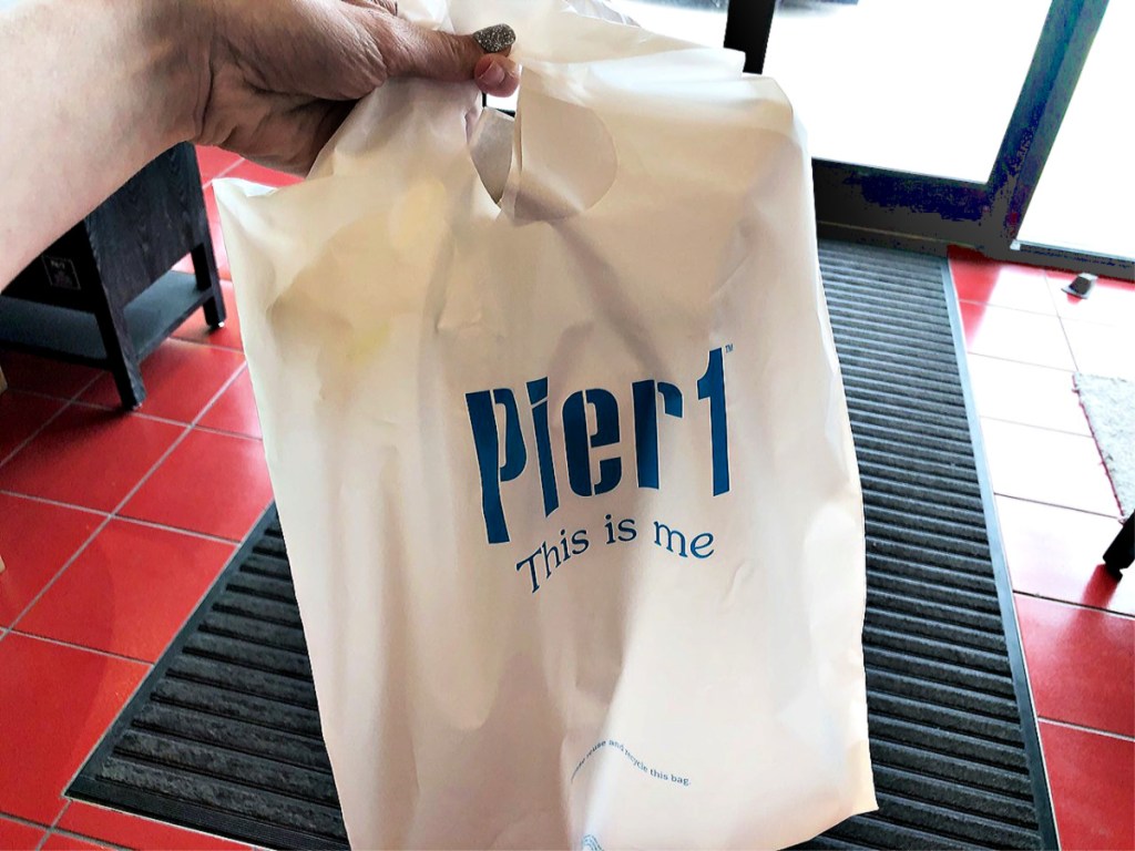 Pier 1 shopping bag in hand at store
