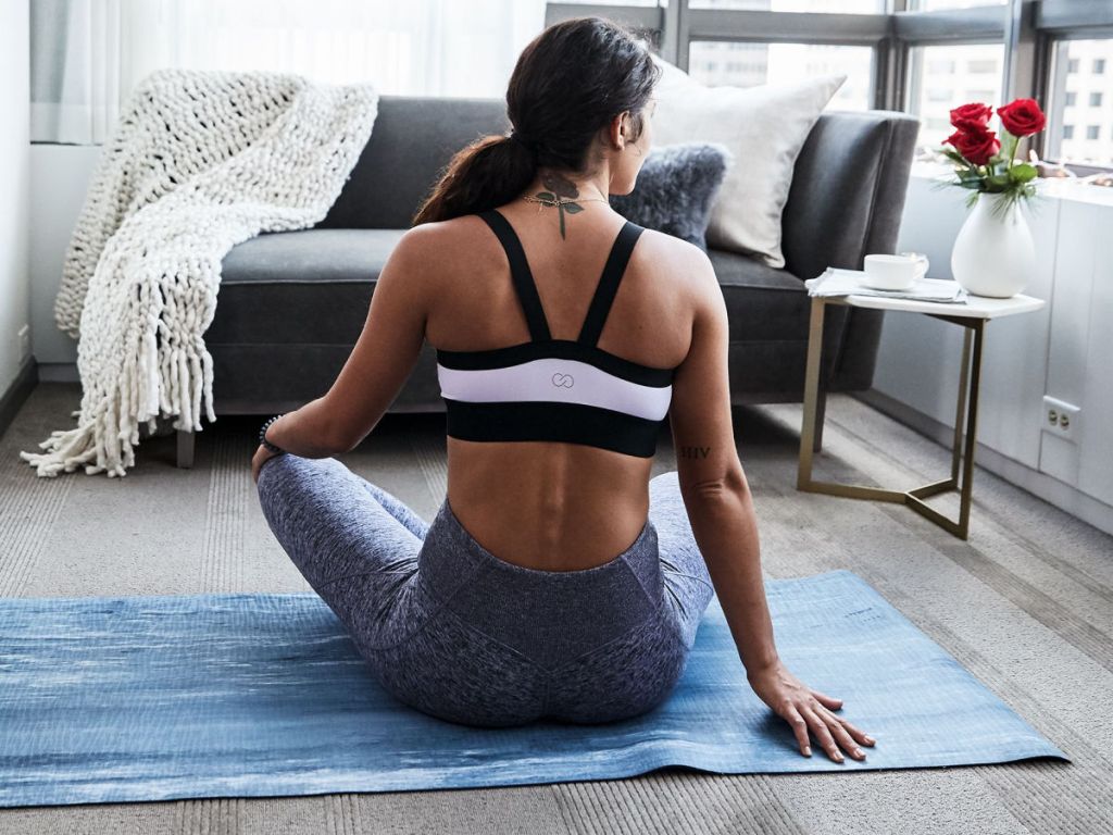 woman wearing pink calia sports bra sitting on yoga mat