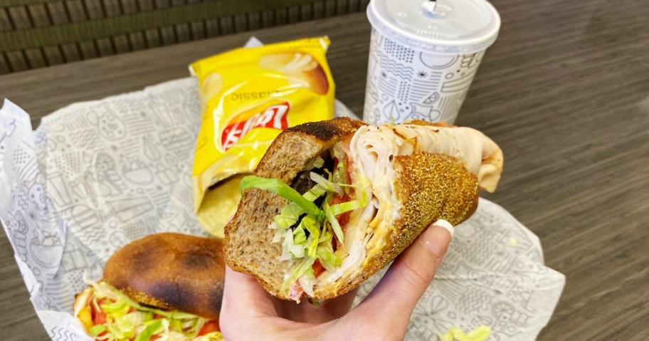 woman holding a sub sandwich
