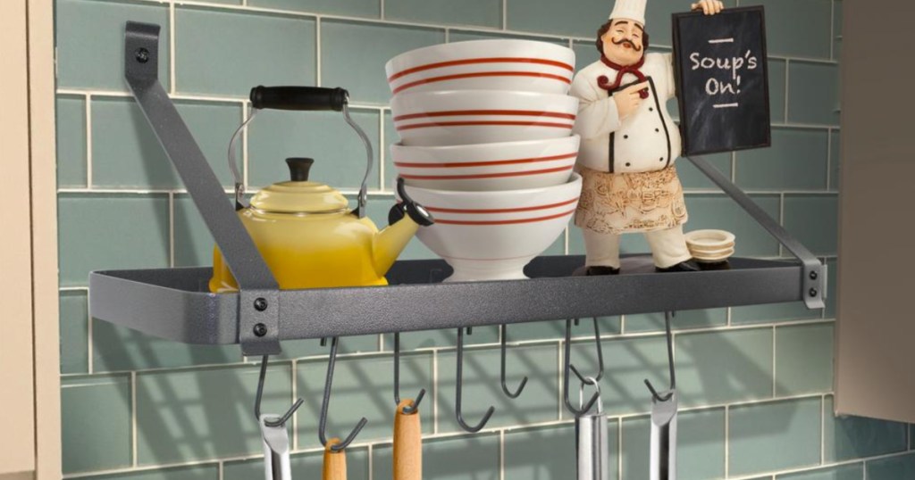 storage pot rack with bowls and a kettle on shelf and utensils hanging off of it
