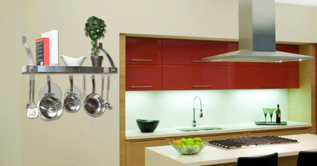 stainless steel pot rack with pans and utensils stored above and hanging off in kitchen