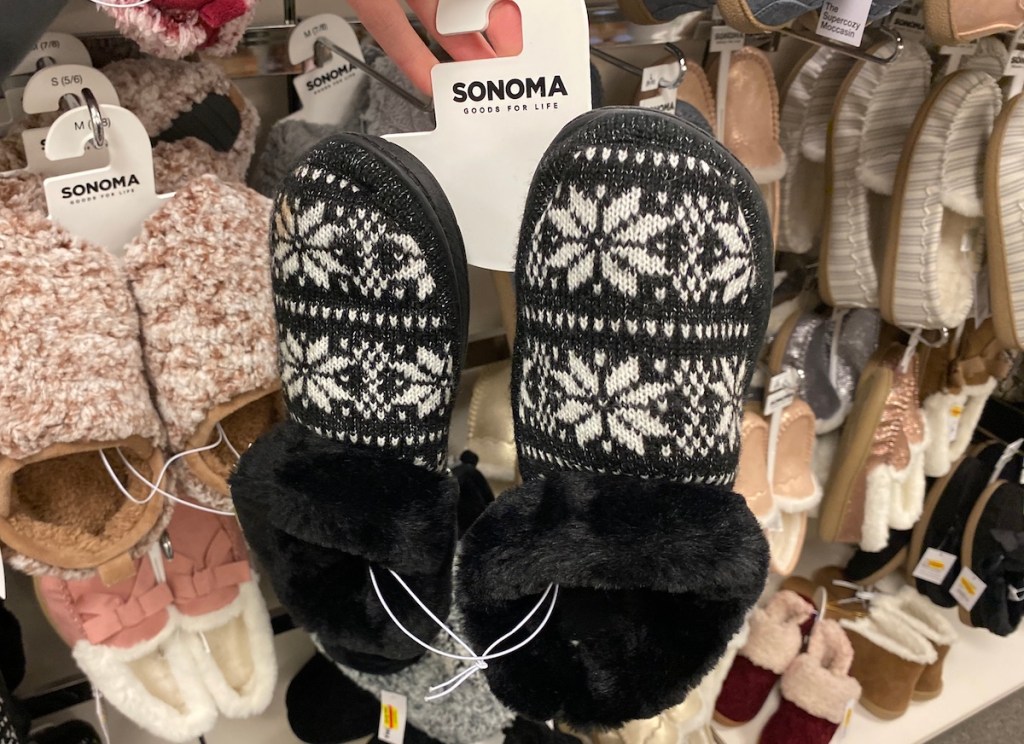woman holding tag on a pair of women's slippers