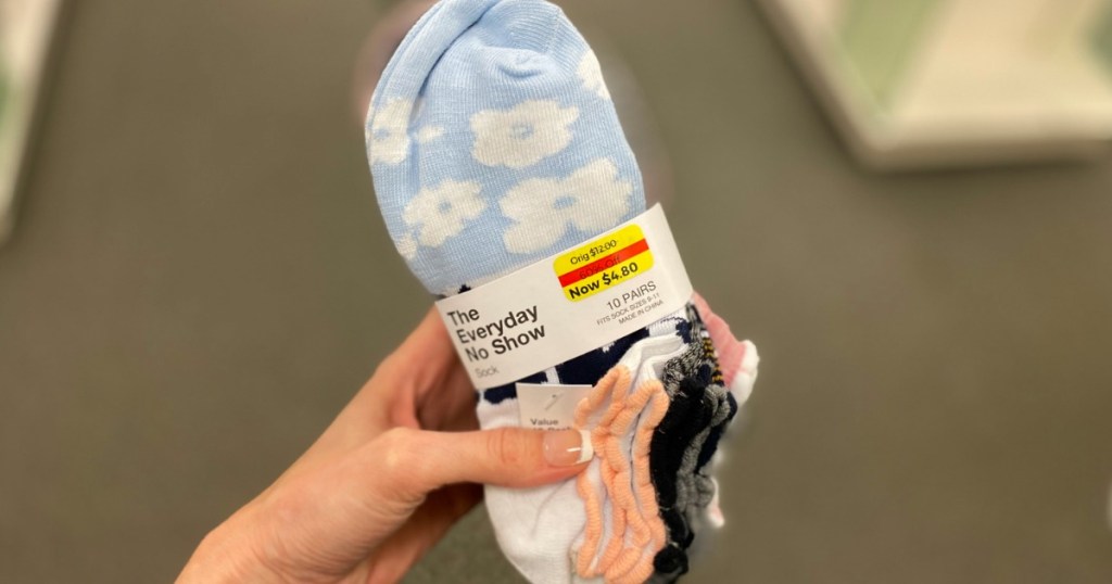 woman holding multi=pack of socks with floral print
