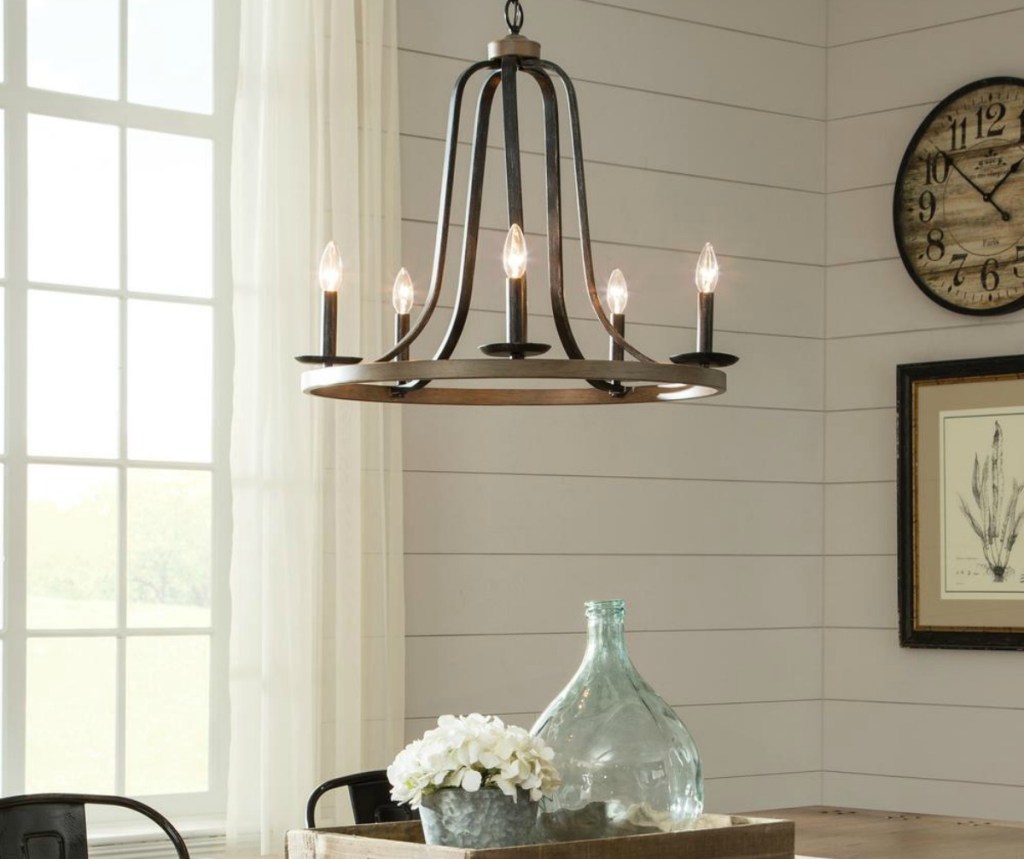 wood and metal chandelier hanging over table decorated with farmhouse style accents