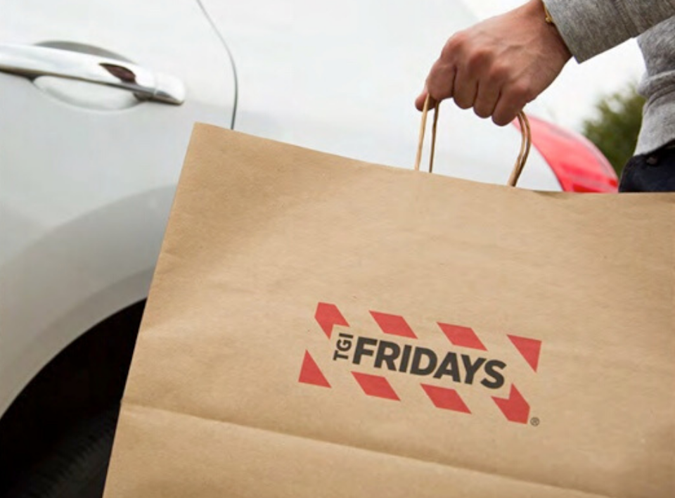 hand carrying a TGI Fridays takeout bag