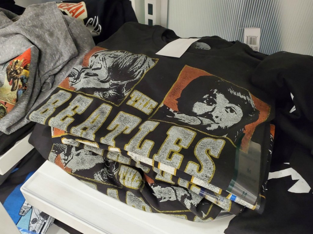 Men's The Beatles graphic tee shirt in black, folded on an in-store shelf