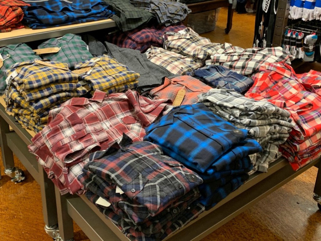 A large variety of men's flannel shirts folded and on display in-store