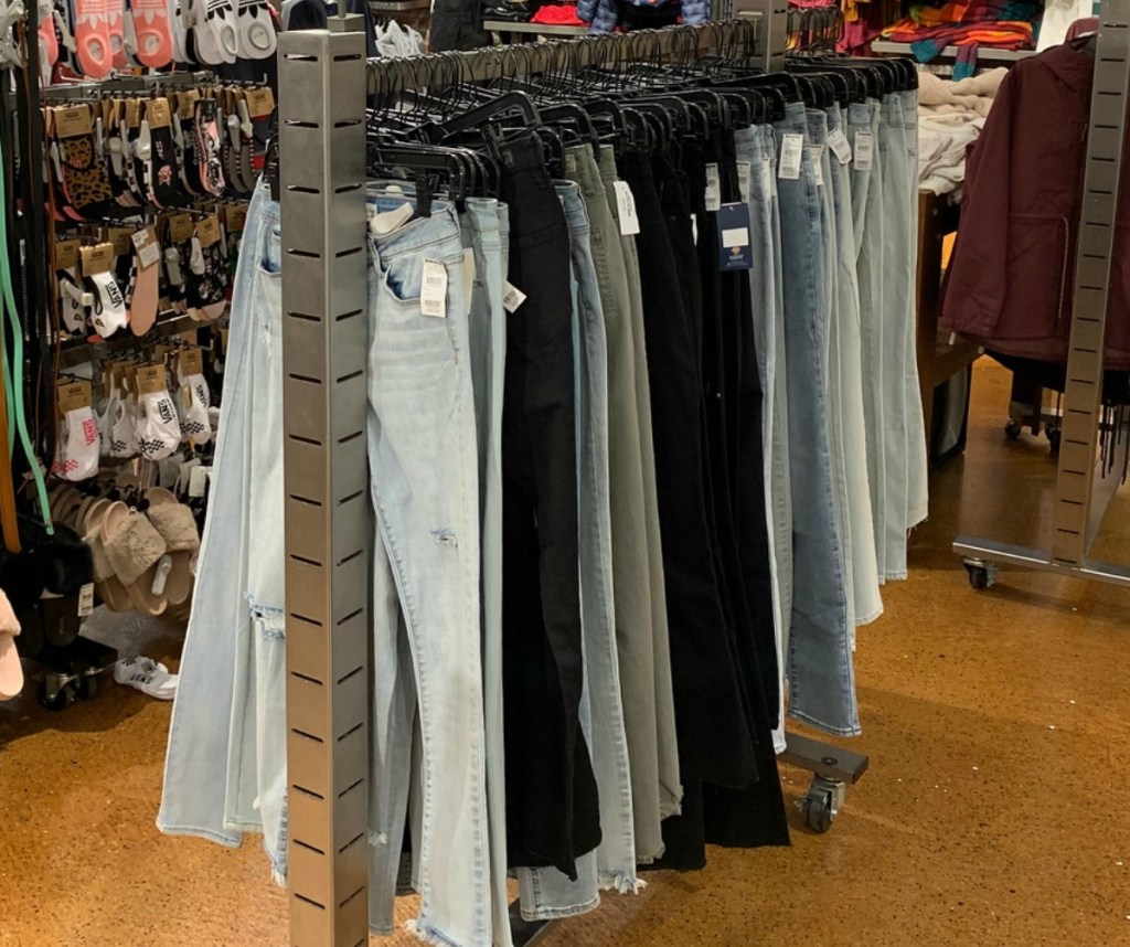 In store display of women's jeans on hangers in various shades of denim