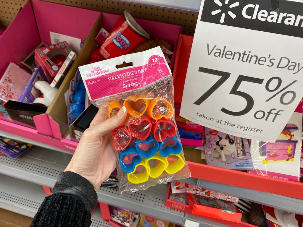 hand holding bag of Valentine's Day favors by sign at Walmart
