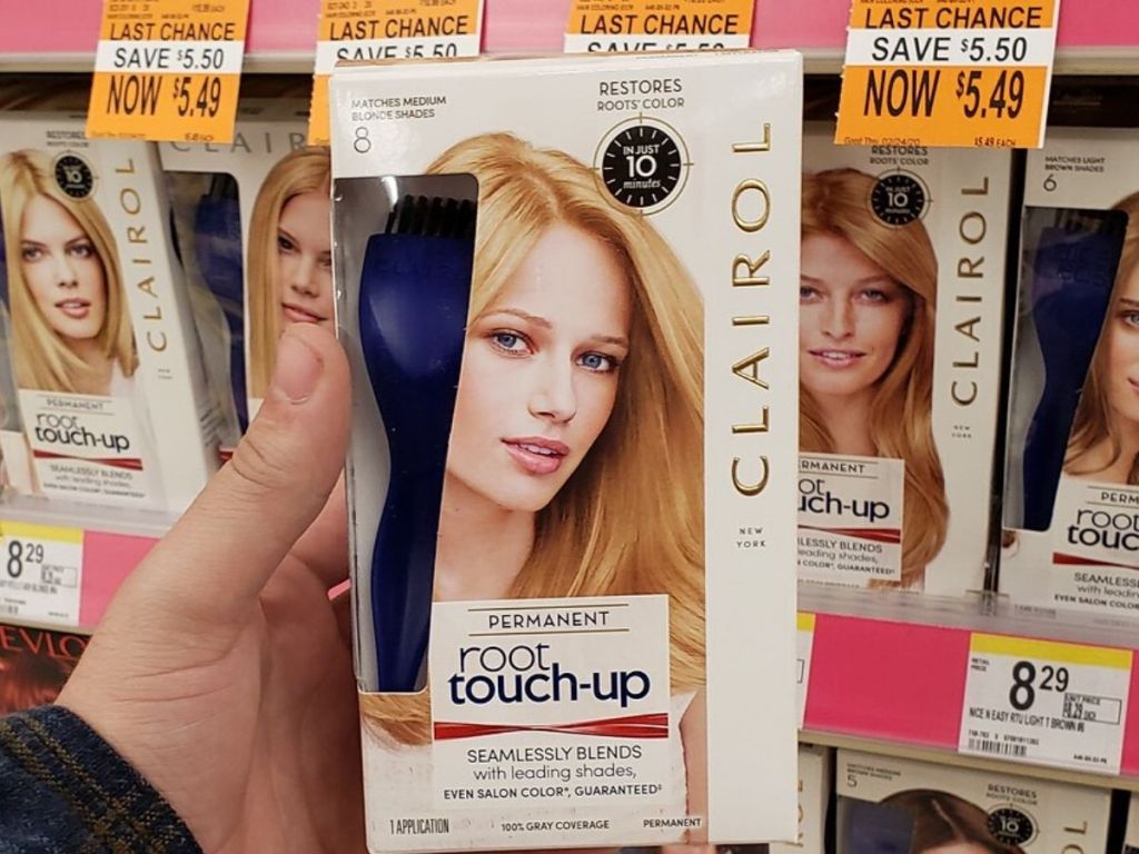 woman's hand holding box of hair dye at store 