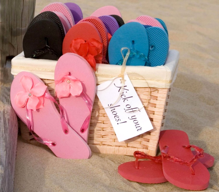 various colors of flip flops in basket in sand - dollar tree wedding