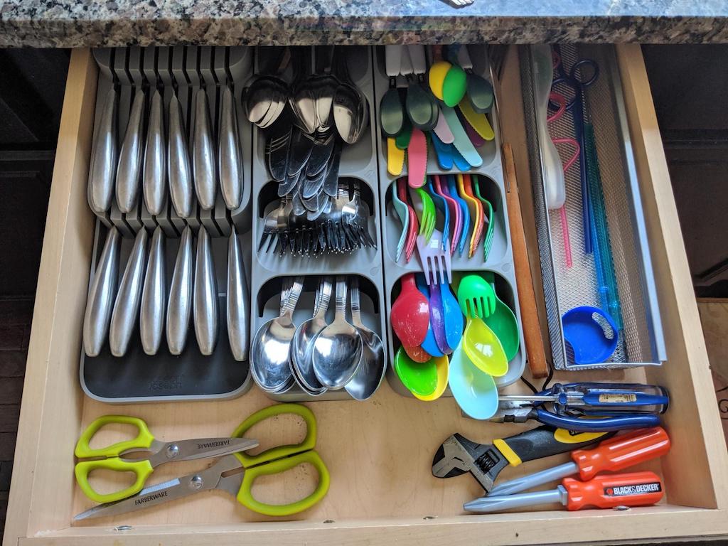 organized kitchen drawer with organizers and cutlery 