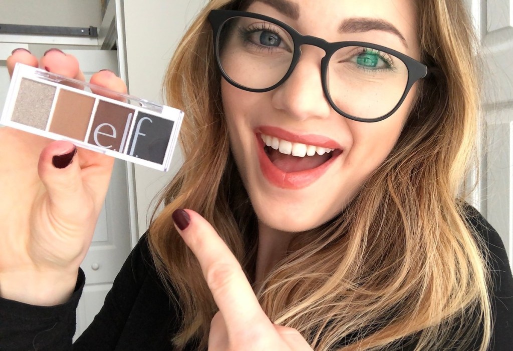 woman smiling and pointing to elf eyeshadow palette