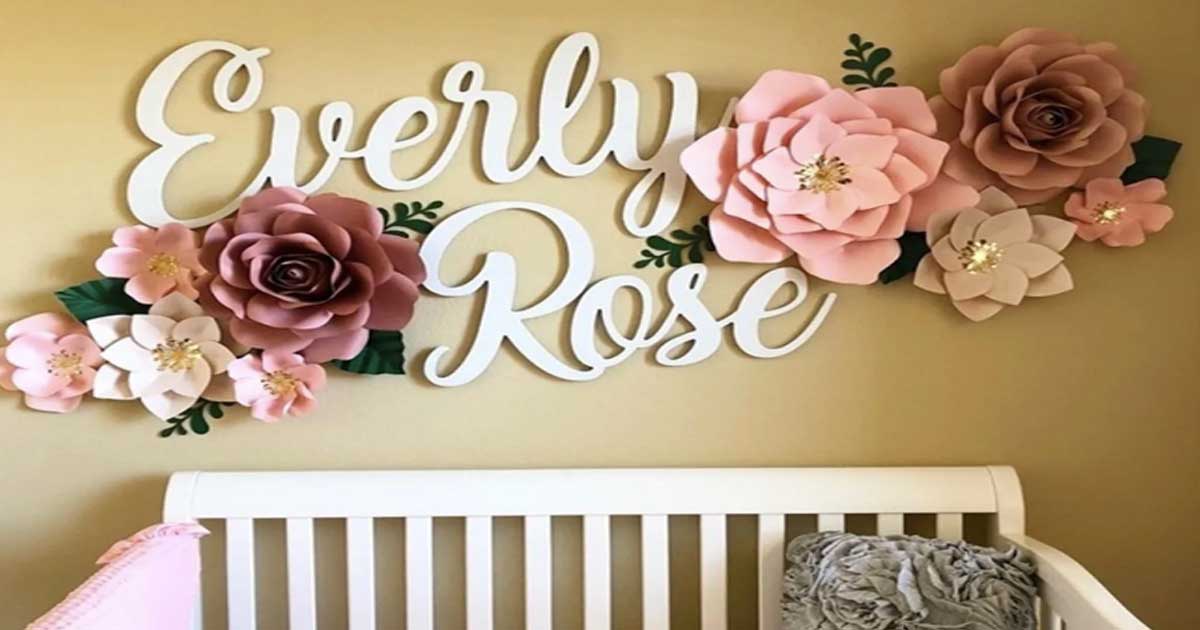 wooden name sign hanging on wall with flowers above a crib