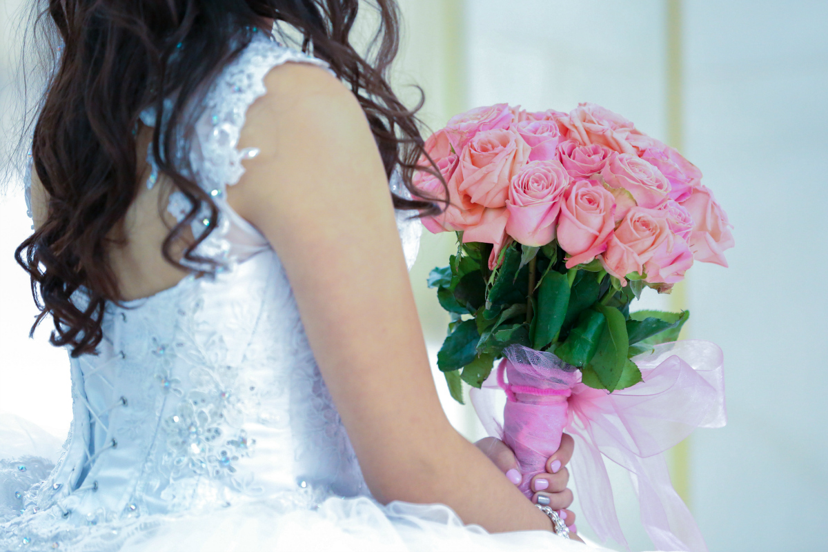 girl holding pink rose bouquet - dollar tree wedding