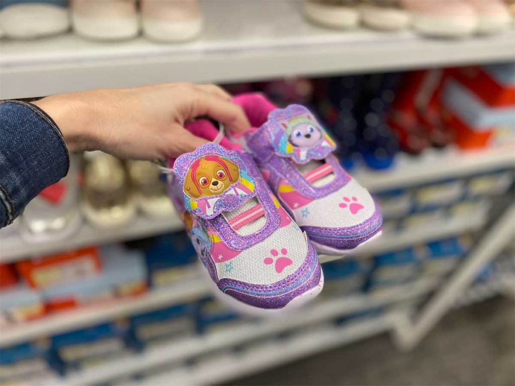 hand holding pair of kids paw patrol shoes