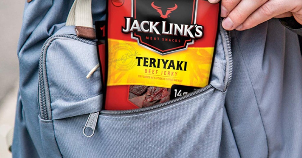 hand putting jack links teriyaki beef jerky in blue book bag