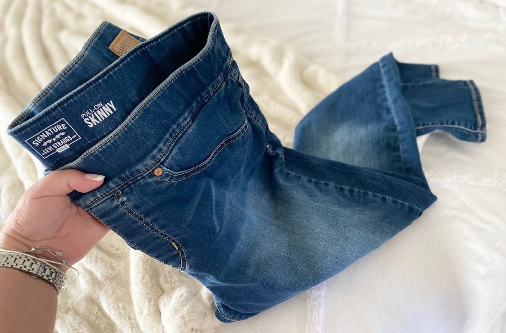 hand holding a pair of jeans 