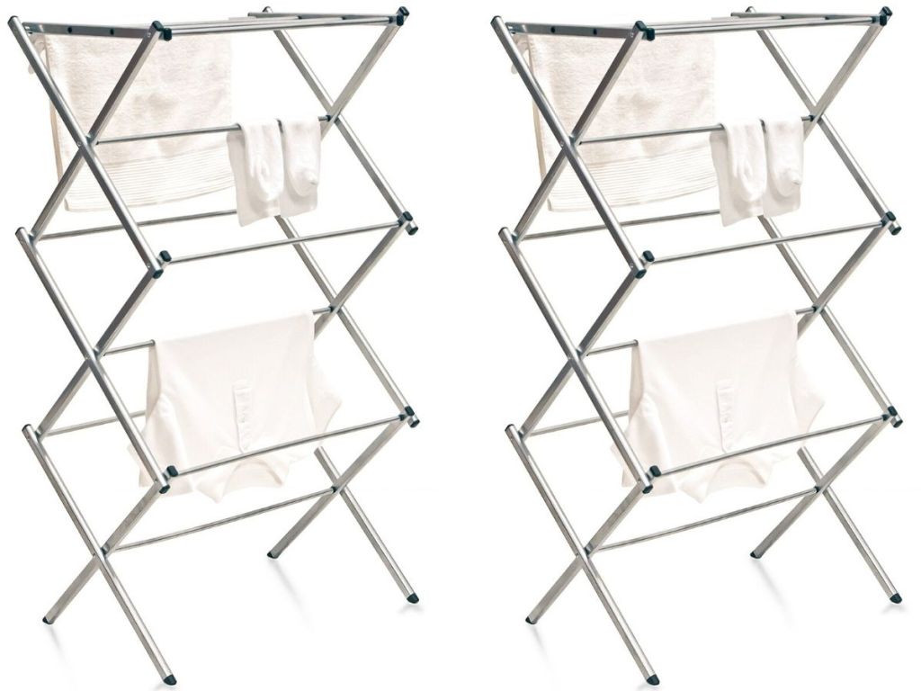 two metal folding drying racks with clothes hanging on them drying