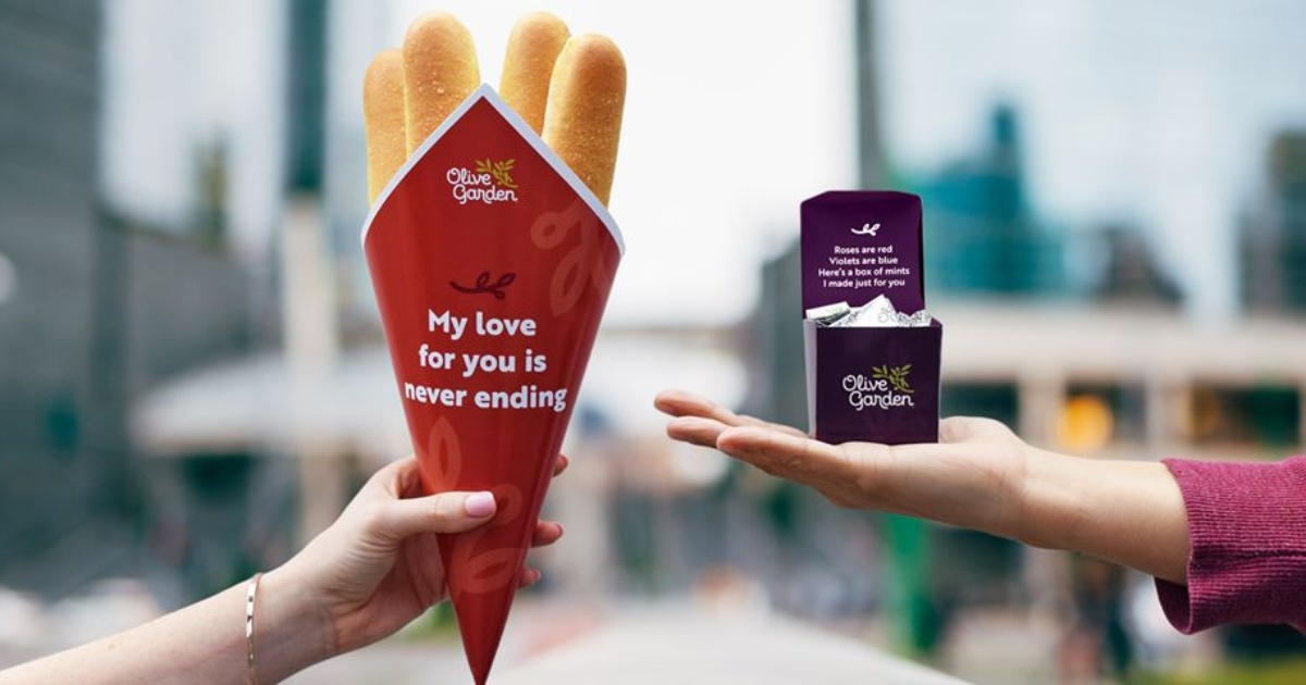 hands holding breadstick bouquet and candy box