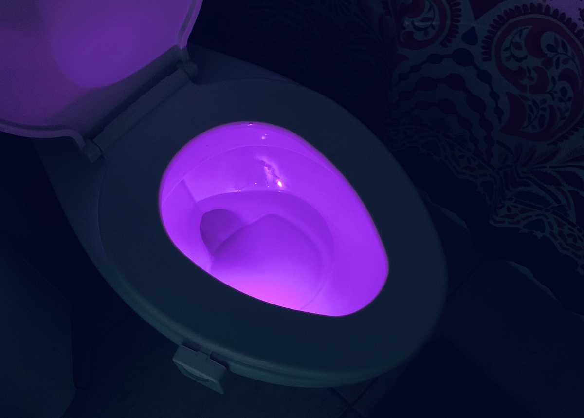 toilet seat with purple light on inside of the bowl
