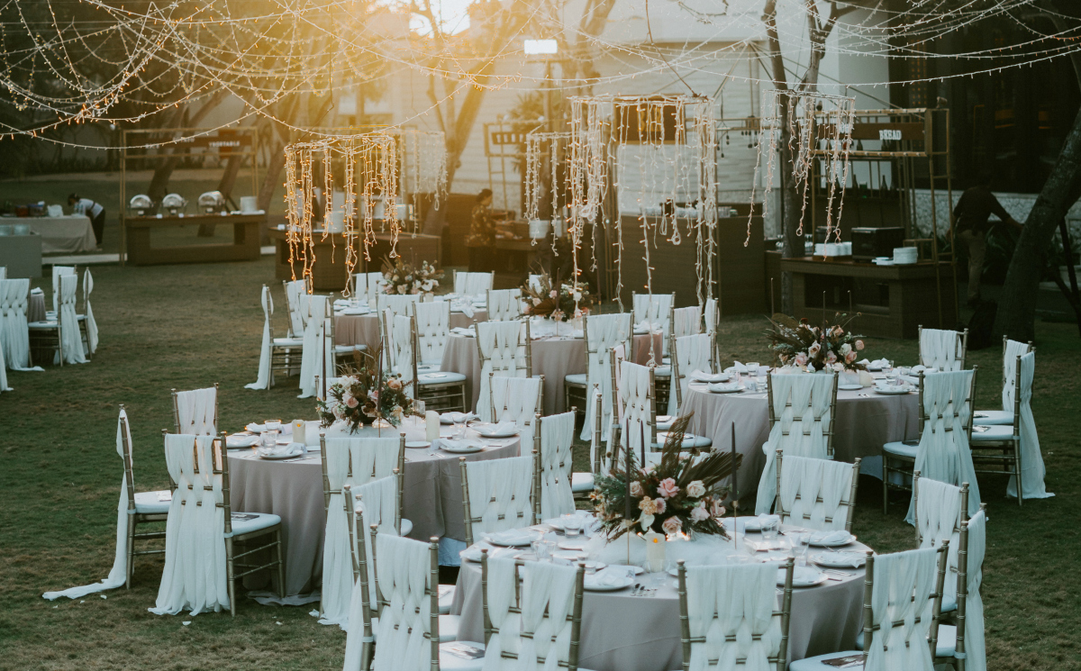 outdoor wedding with tables chairs and various string lights hanging from sky - dollar tree wedding