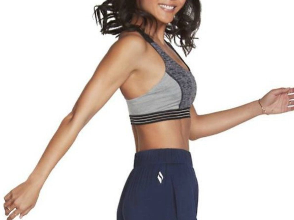 woman standing sideways in sports bra and sweatpants