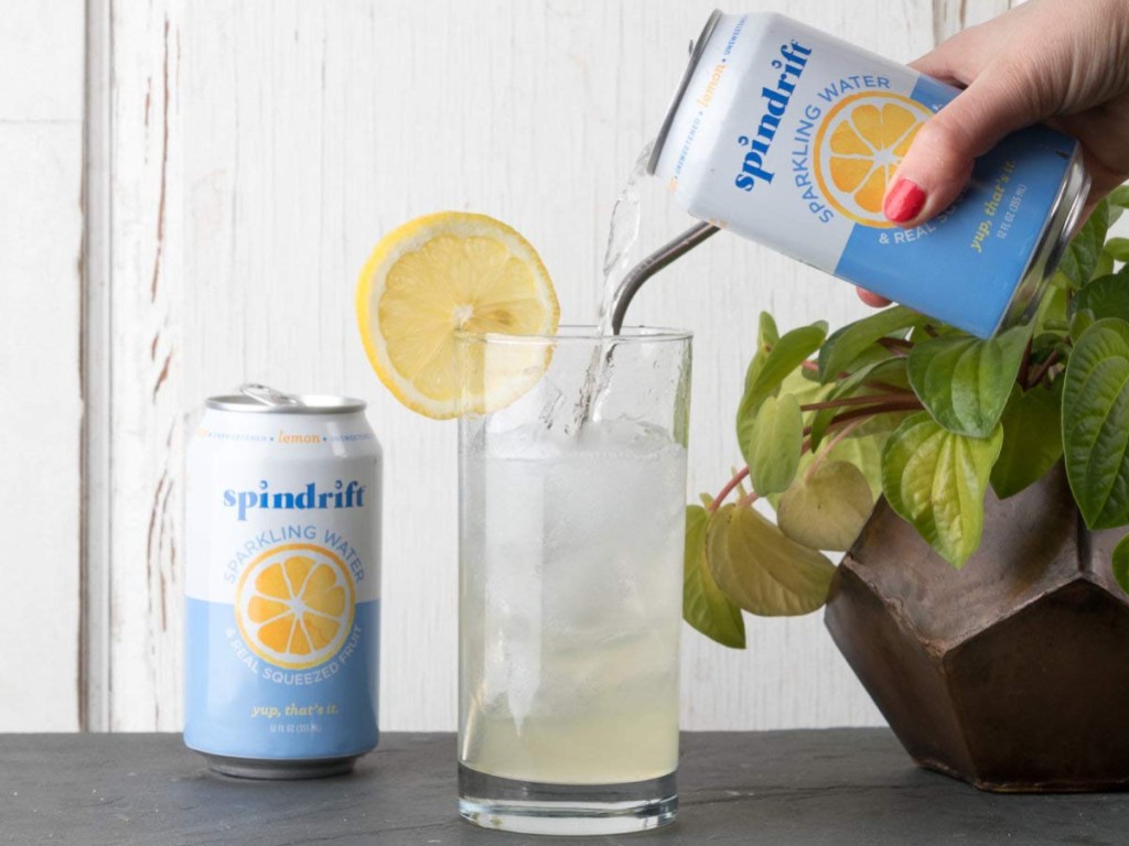 woman pouring a can of lemons spindrift into a glass