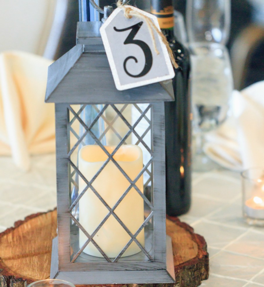 close up of metal lantern with candle inside and number 3 hanging from the top - dollar tree wedding