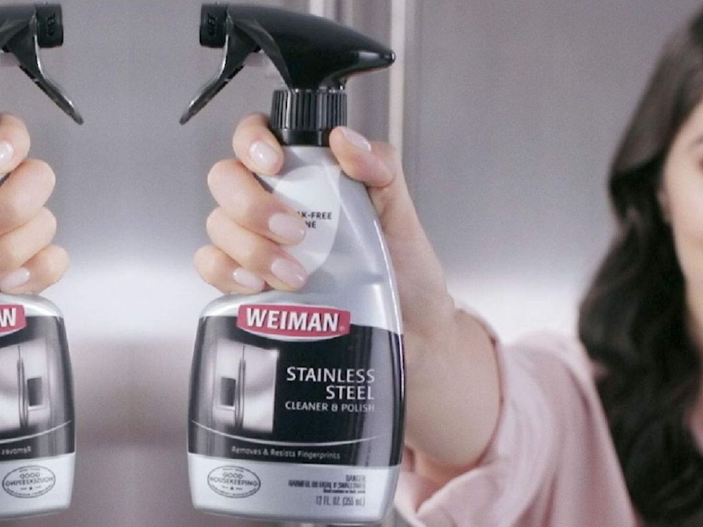 woman holding up bottle of stainless steel cleaner