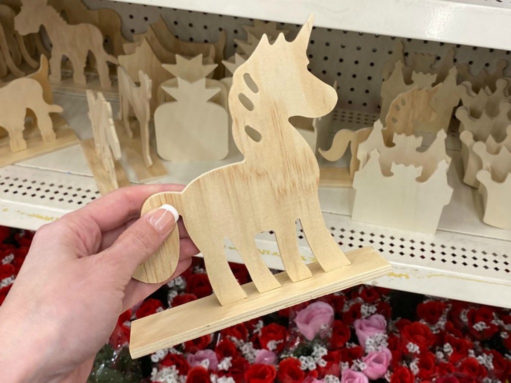 hand holding wooden unicorn by store display