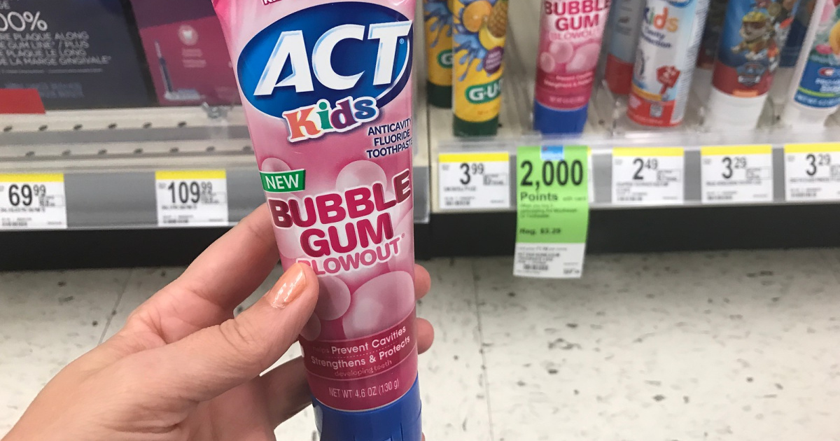 Hand holding ACT bubble gum toothpaste in store