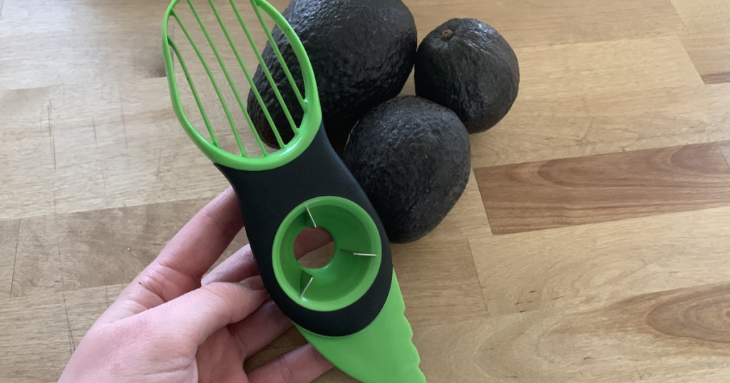 green avocado peeler knife with ripe avocados on the counter