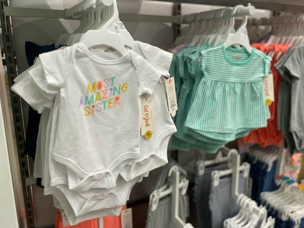 Baby bodysuits on hangers in-store on display