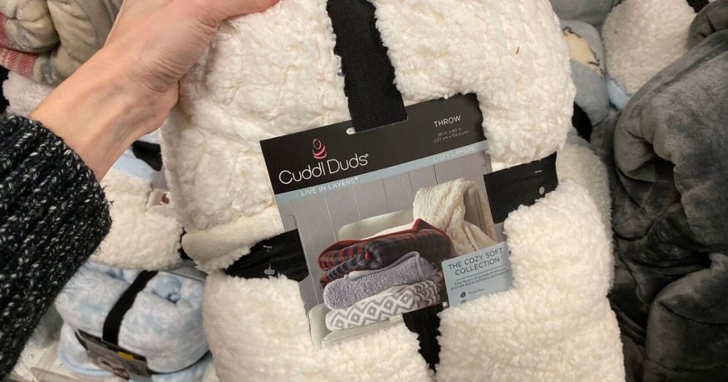 human hand holding new sherpa throw in packaging at store