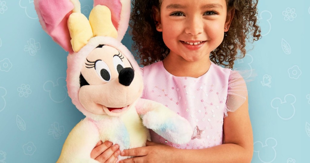 Young girl holding a large plush bunny themed Minnie Mouse