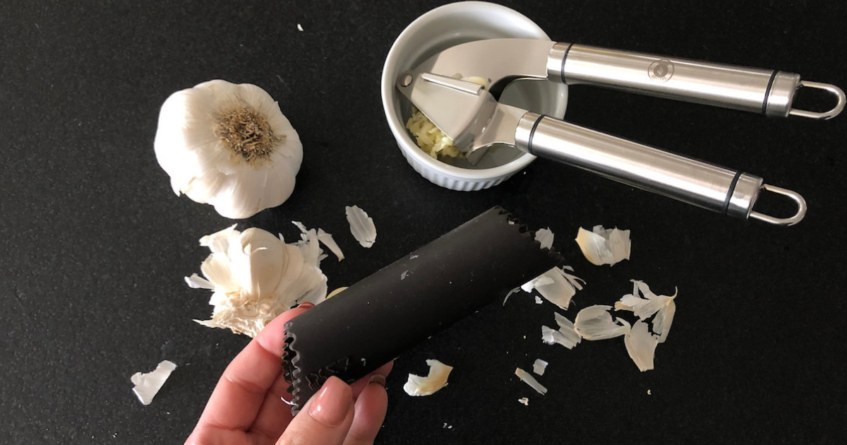 silicone roller with peeled garlic press and bowl in the background