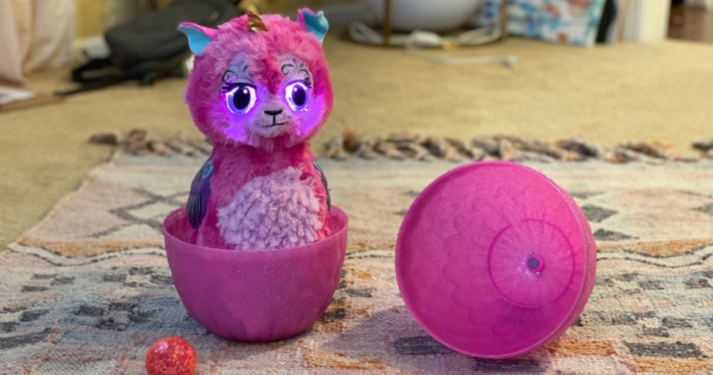 pink llama unicorn hatching toy on carpet in home