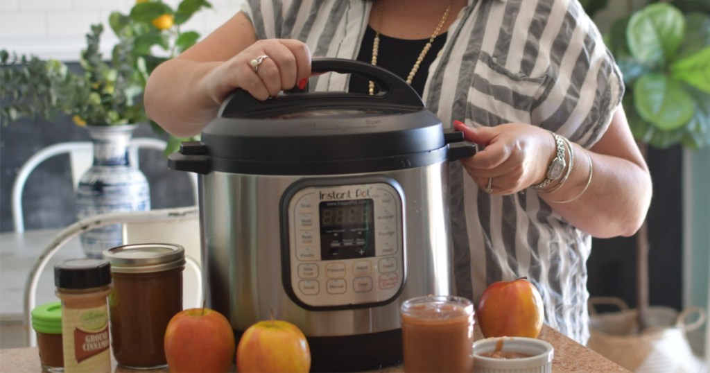 woman standing behind instant pot with hand on lid