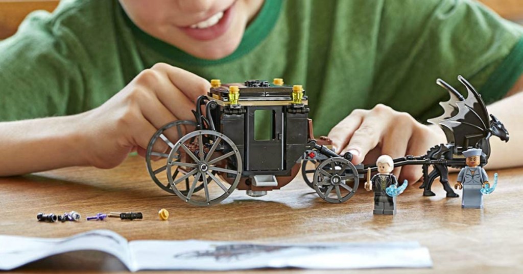 little boy playing with a lego harry potter set 