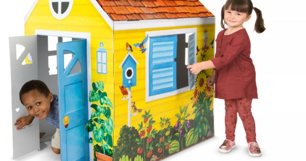 boy and girl playing in a cardboard playhouse