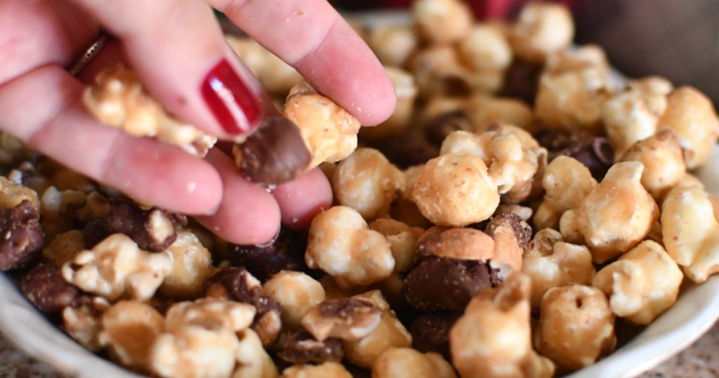 hand reaching for a bowl of moose munch popcorn treats