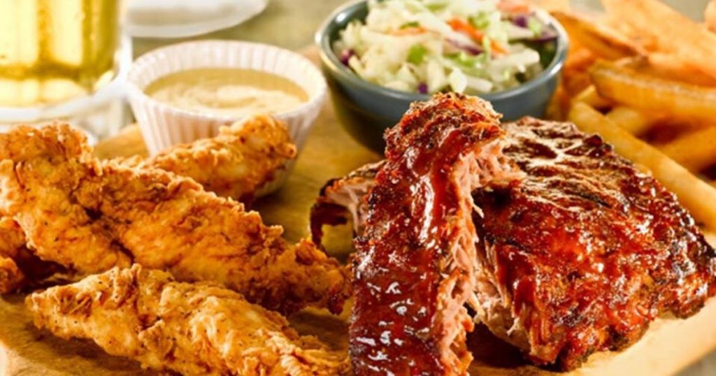 fried chicken, spare ribs, coleslaw and honey mustard in a ramekin on a cutting board served at a restaurant